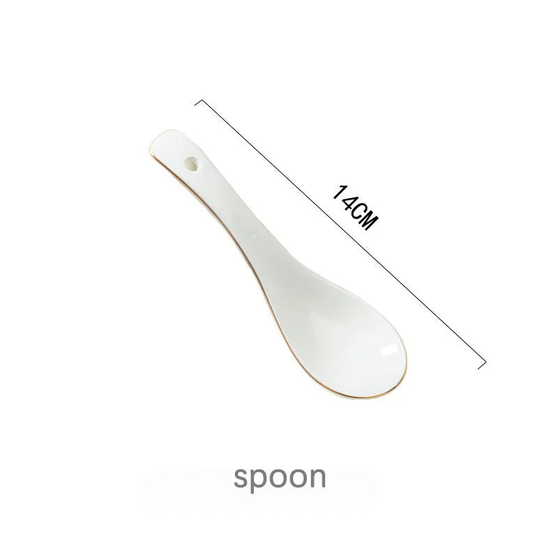 weisse keramik porzellanteller mit elegantem goldrand auf esstisch