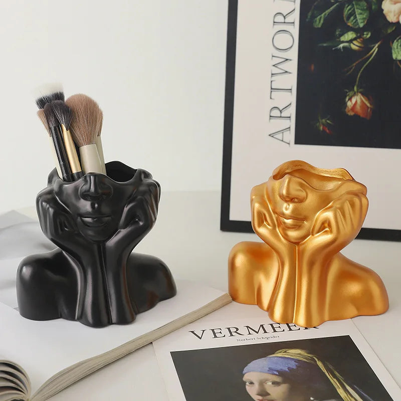 Abstrakter nordischer Pinselhalter in Schwarz und Gold, aus Kunststoff.